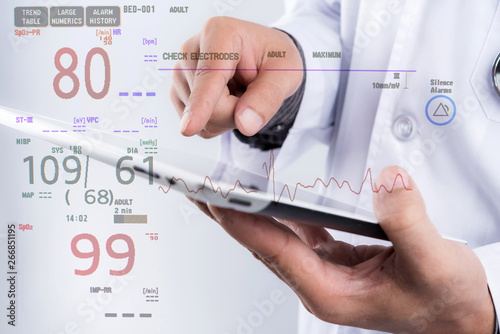Doctor hold tablet in hand with electrocardiogram monitor showing patient heart rate, medical rescue concept.