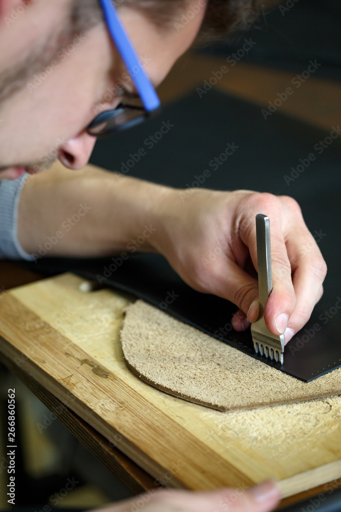 Leather craftsman working with natural leather. Handmade concept. Concept of small business to create leather products. Leather craftsman working with natural leather. Handmade concept. Concept of small business to create leather products.