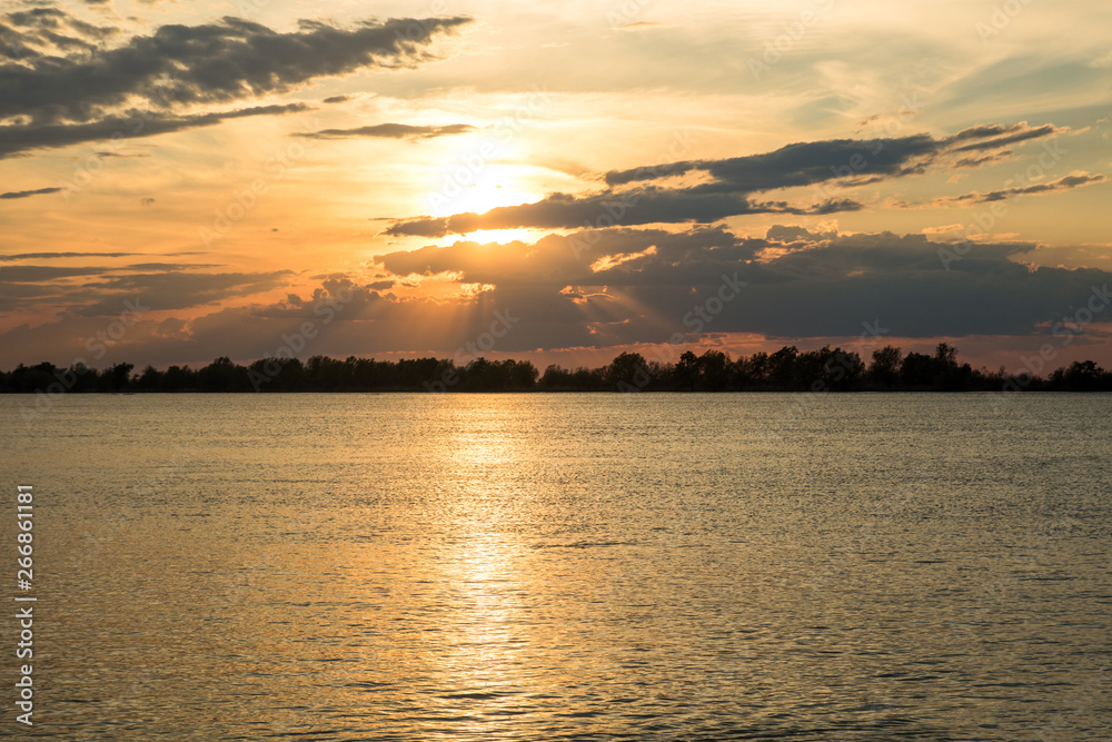 Fototapeta premium scenic orange sunset with beautiful clouds and blue sky on the river danube