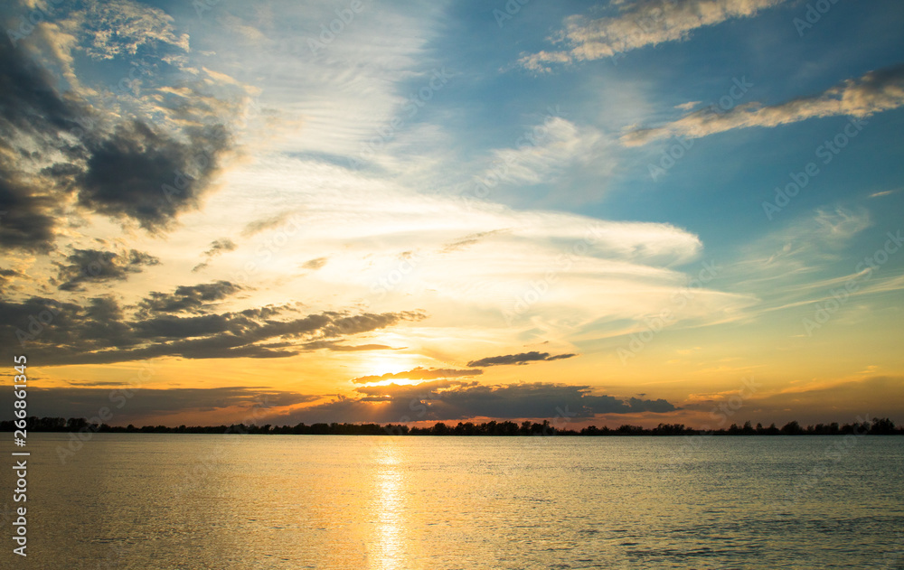 scenic orange sunset with beautiful clouds and blue sky on the river danube