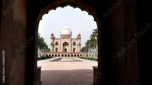 a zoom in shot of safdarjung's tomb framed by an arch in delhi, india