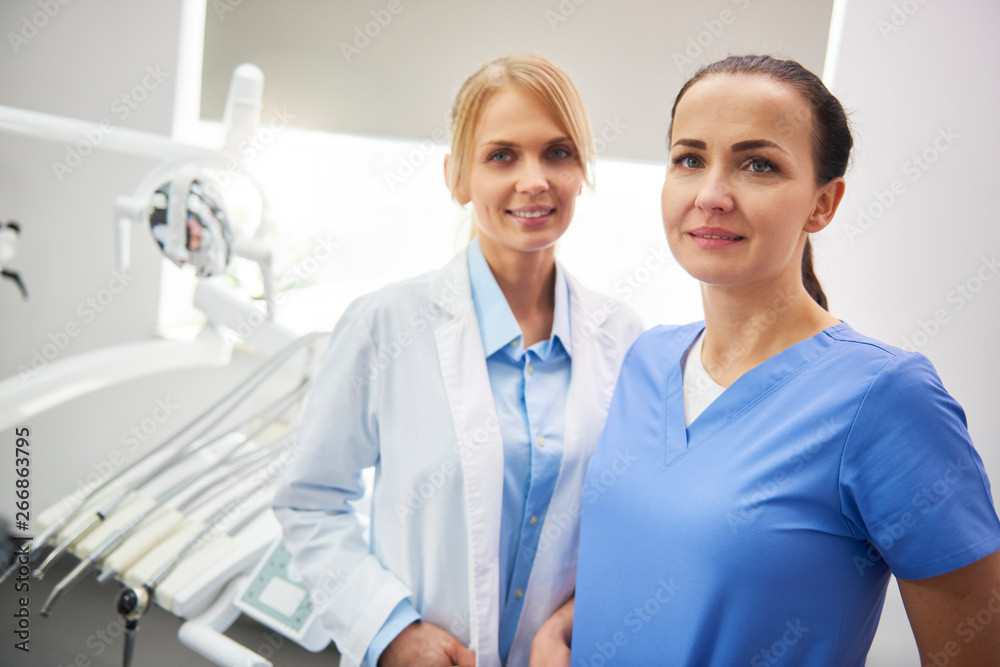 Portrait of happy stomatologist and her dental assistant Portrait of happy stomatologist and her dental assistant