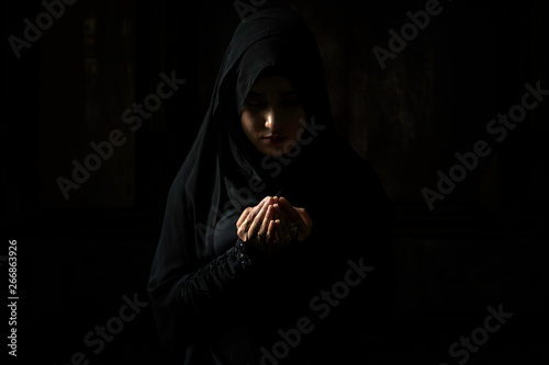 Muslim women wearing black shirts Doing prayer According to the principles of Islam..
