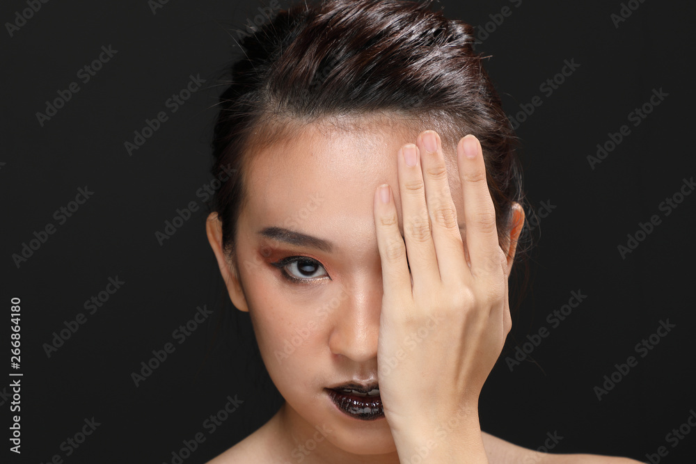 Young beautiful Asian woman makeup dark background Young beautiful Asian woman makeup dark background