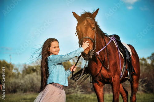 Beautiful girl with horse on the grass. Friendship concept.