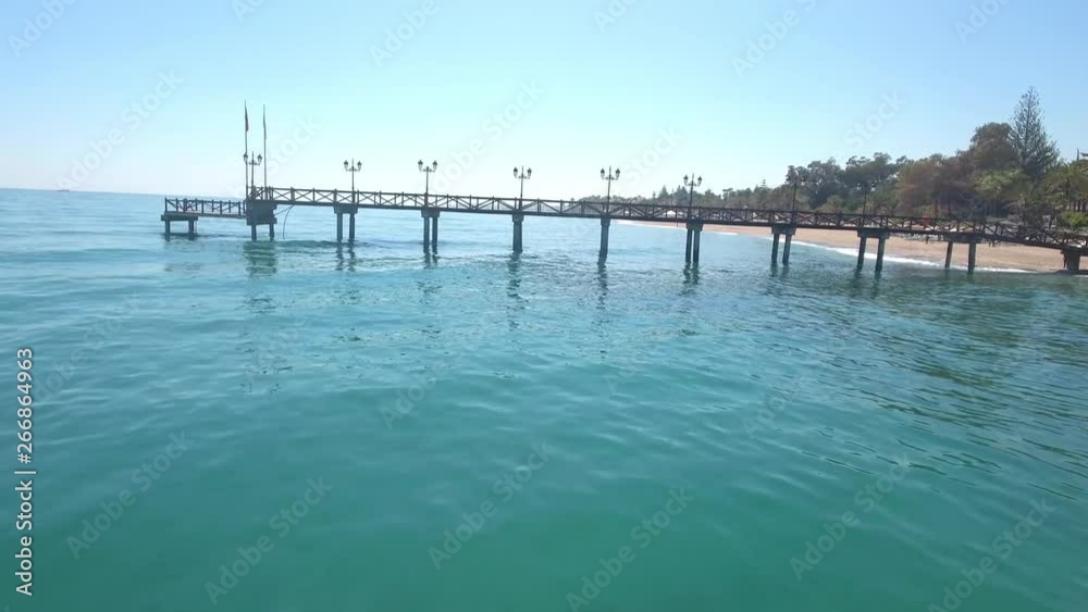 drone flying under pier, dangerous risky flight ona beautiful sunny beach in marbella, malaga, spain, costa del sol. stunning vacation footage in 4k. drone flying under pier, dangerous risky flight ona beautiful sunny beach in marbella, malaga, spain, costa del sol. stunning vacation footage in 4k.