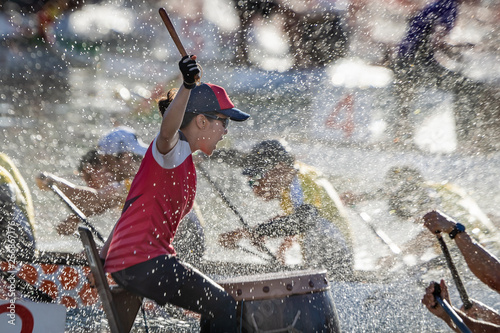 dragon boat drummer racing through spray