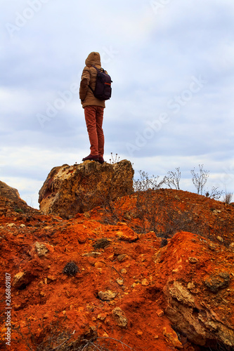Man standing on rock. Tourist stand alone on a rock and watching horizont within sunset