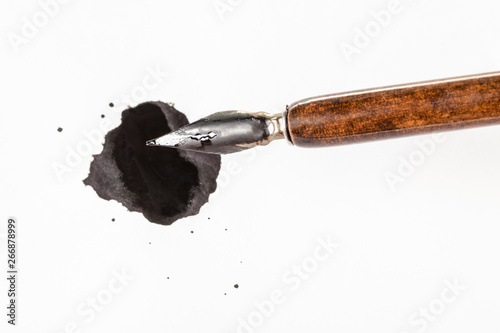 фотографія top view of brown nib pen over black ink blot