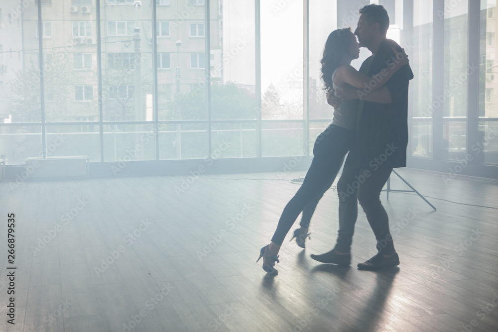 Kizomba dancers showing their passion for dancing kizomba in front a dancing room with big windows in the background