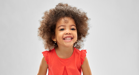 childhood and people concept - happy little african american girl over grey background