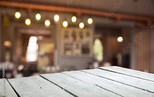 image of wooden table in front of abstract blurred background of resturant lights