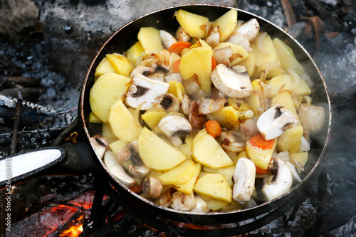 cooking on the nature, fried potatoes with mushrooms and vegetables