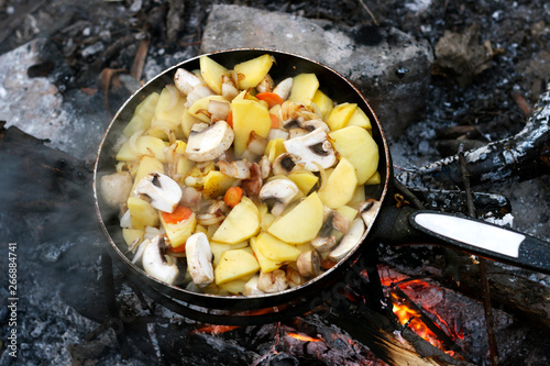 cooking in nature, fried potatoes with mushrooms and vegetables on the fire