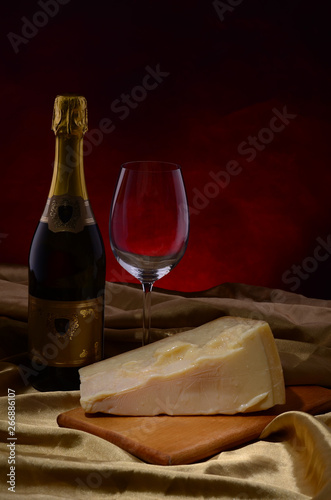 Red wine, assorted cheeses, bread and grapes in a still life setup