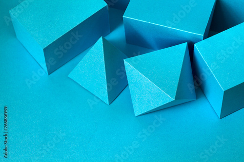 Blue color geometrical figures still life composition. Three-dimensional prism pyramid rectangular cube objects on blue background. Platonic solids figures, abstract simplicity concept. selective