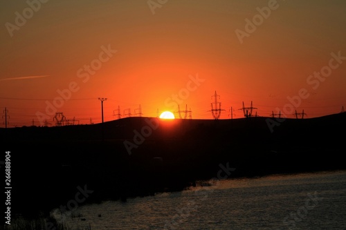 sunset through voltage poles on the hill © sebi_2569