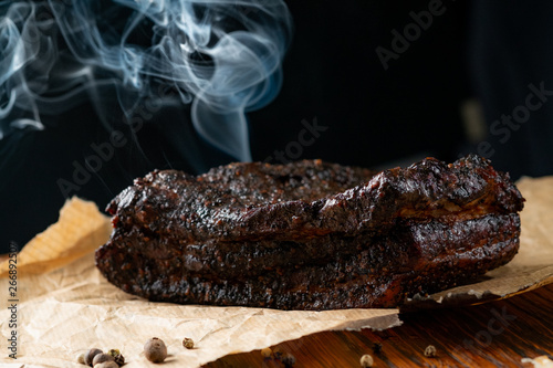 Smoked Beef Brisket BBQ with a dark bark on a wooden board photo