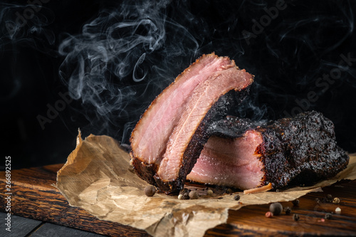 Smoky sliced beef brisket with dark crust from classic Texas smokehouse on a dark background photo