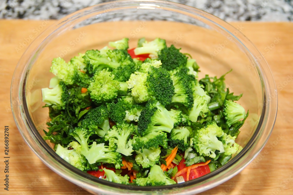 green broccoli salad in a glass plate on a wooden board background green broccoli salad in a glass plate on a wooden board background