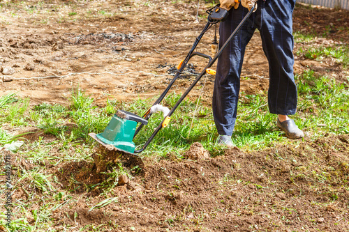 Man plows the earth with a cultivator