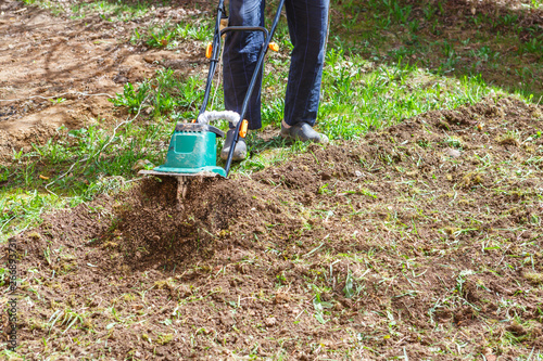 Man plows the earth with a cultivator
