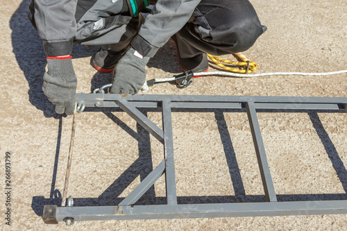 Worker electrician fastened by a safety belt