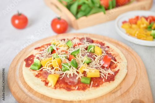 Raw pizza dough with tomato sauce, ingredients