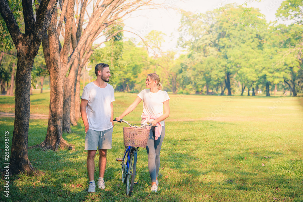Fototapeta premium Portrait image of Young couple enjoying in the park at sunset. Concept romantic and love. Warm tone.