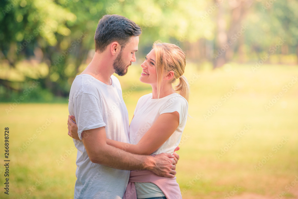 Portrait image of Young couple enjoying in the park at sunset. Concept romantic and love. Warm tone.