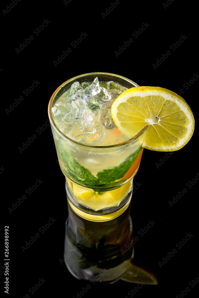 Alcoholic or non-alcoholic cocktail with lemon, lime and cucumber with the addition of liquor, vodka, champagne or martini. Cool drink isolated on black background. Cocktail card for a bar Alcoholic or non-alcoholic cocktail with lemon, lime and cucumber with the addition of liquor, vodka, champagne or martini. Cool drink isolated on black background. Cocktail card for a bar