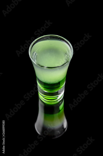 Green mexican. Alcoholic cocktails in shot glasses (shooters).  Cool drink from strong vodka, whiskey and sweet liqueurs isolated on black background. Cocktail card for a bar or restaurant.