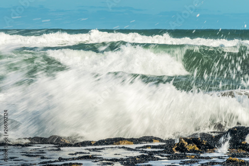 Sea waves hitting on the stones near the coast. White foam comes out of the waves white foam of a sea wave