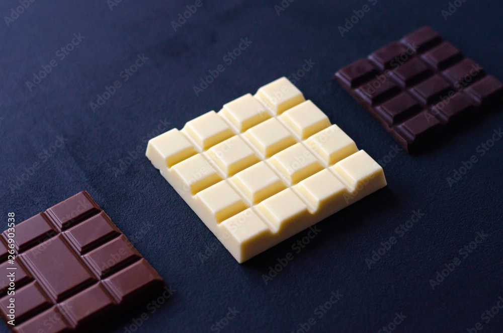 A stack of different chocolate in on a black background.