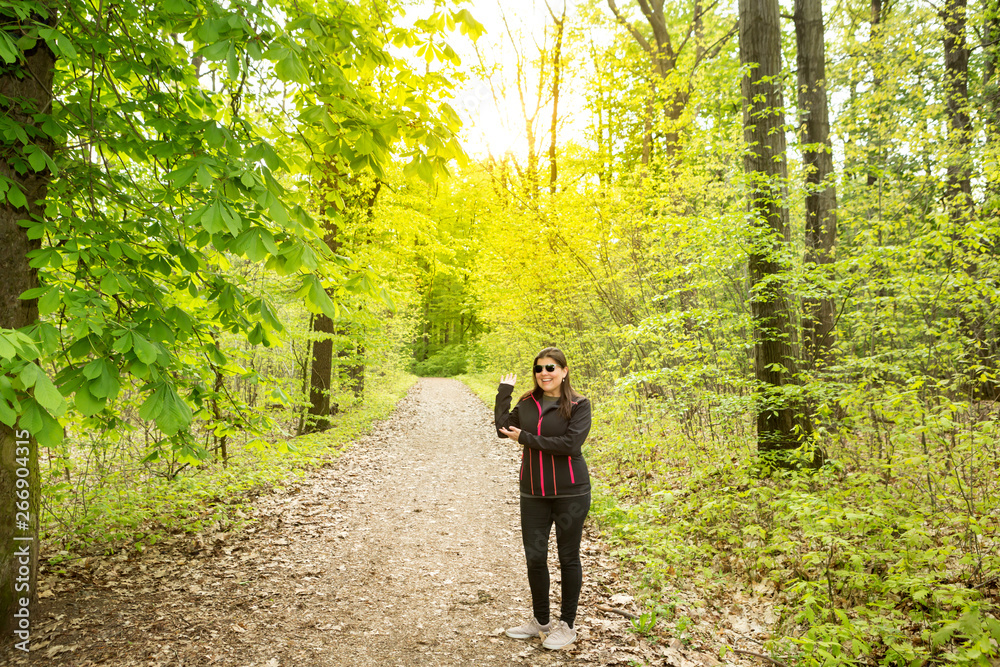 Lady makes gesture as presenting or showing something in the forest, image adaptable for advertising product or message presentation Lady makes gesture as presenting or showing something in the forest, image adaptable for advertising product or message presentation