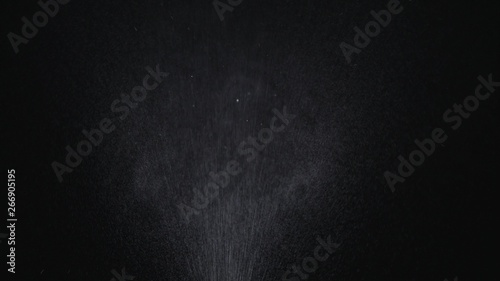 White exploding powder over black background