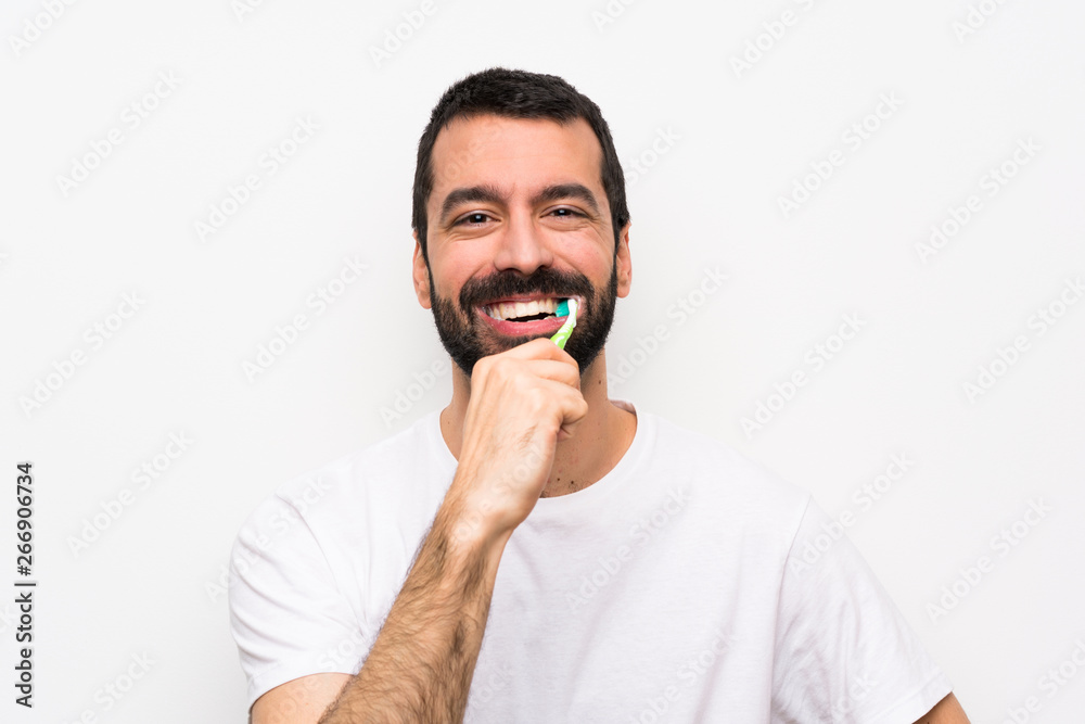 Man with beard brushing teeth over isolated white background Man with beard brushing teeth over isolated white background
