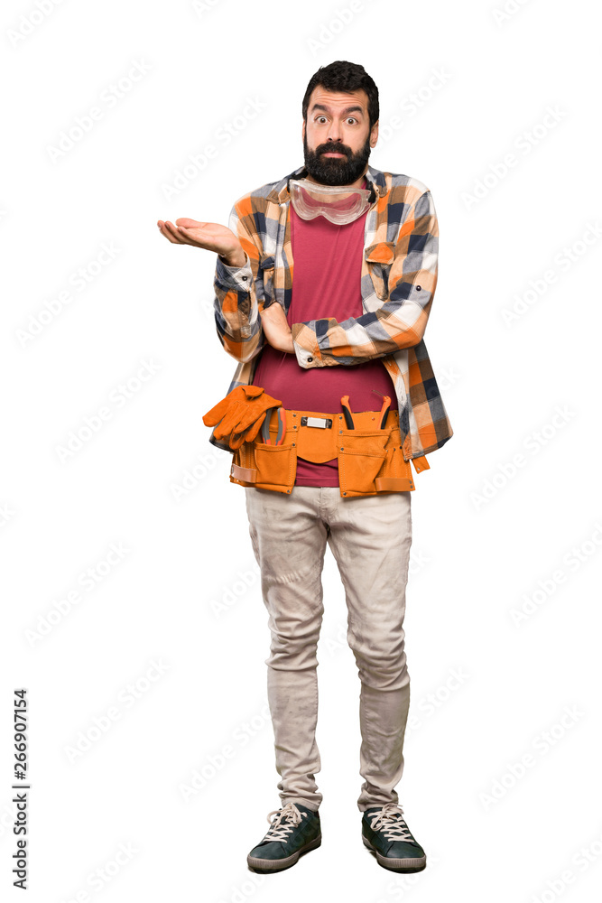 Craftsmen man having doubts while raising hands over isolated white background Craftsmen man having doubts while raising hands over isolated white background