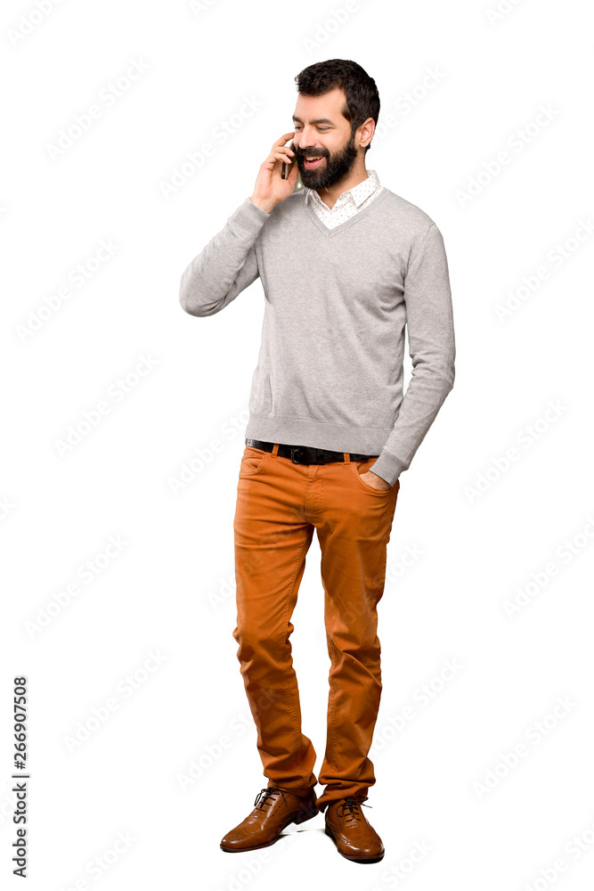 Handsome man keeping a conversation with the mobile phone over isolated white background Handsome man keeping a conversation with the mobile phone over isolated white background