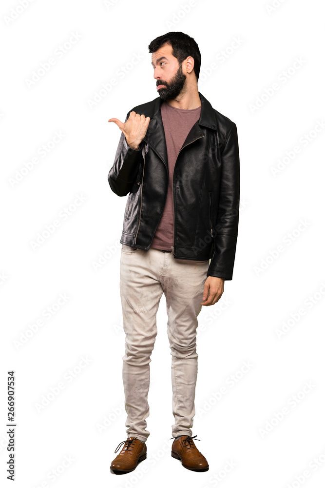 Handsome man with beard unhappy and pointing to the side over isolated white background Handsome man with beard unhappy and pointing to the side over isolated white background