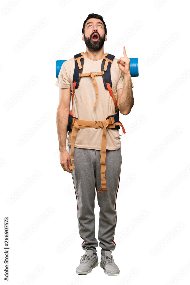 Hiker man pointing up and surprised over isolated white background Hiker man pointing up and surprised over isolated white background