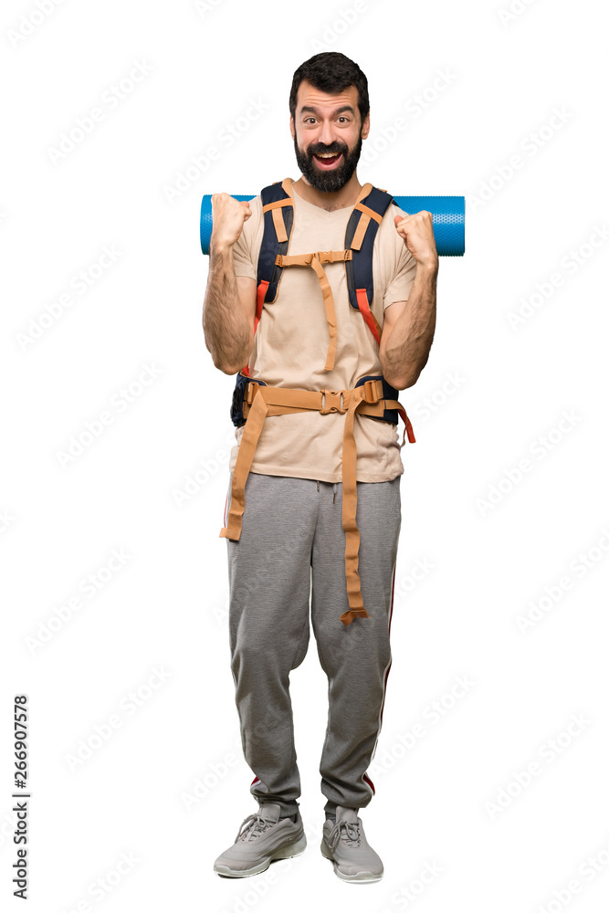 Hiker man celebrating a victory in winner position over isolated white background Hiker man celebrating a victory in winner position over isolated white background