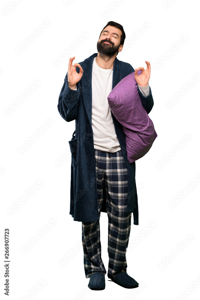 Man with beard in pajamas in zen pose over isolated white background Man with beard in pajamas in zen pose over isolated white background