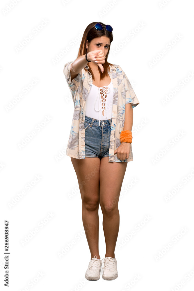 Full-length shot of Young woman in bikini in summer holidays showing thumb down with negative expression over isolated white background Full-length shot of Young woman in bikini in summer holidays showing thumb down with negative expression over isolated white background