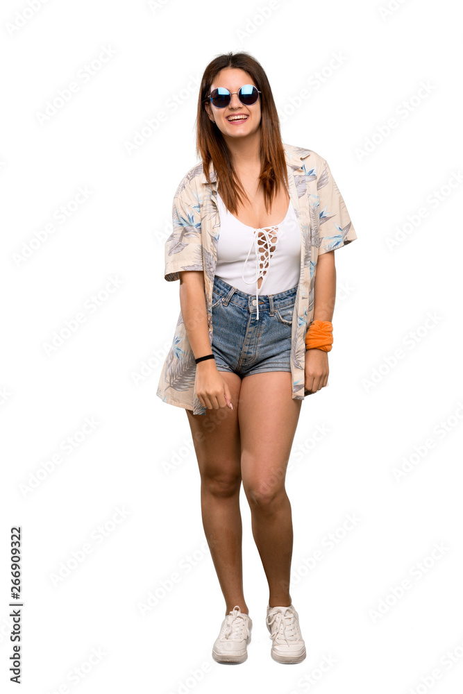 Fototapeta premium Full-length shot of Young woman in bikini in summer holidays with glasses and happy over isolated white background