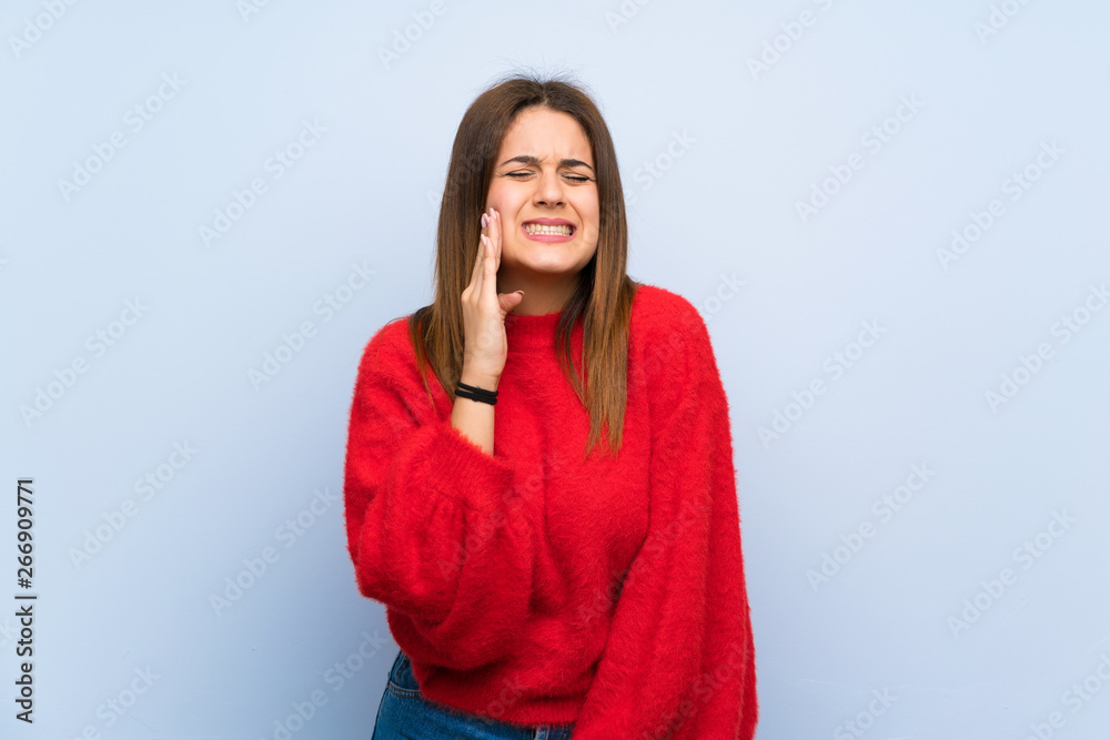 Young woman over isolated blue wall with toothache Young woman over isolated blue wall with toothache