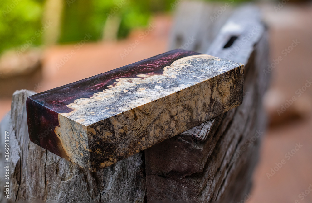 Afzelia burl wood bar casting with epoxy resin Stabilizing for blanks on blurred background Afzelia burl wood bar casting with epoxy resin Stabilizing for blanks on blurred background