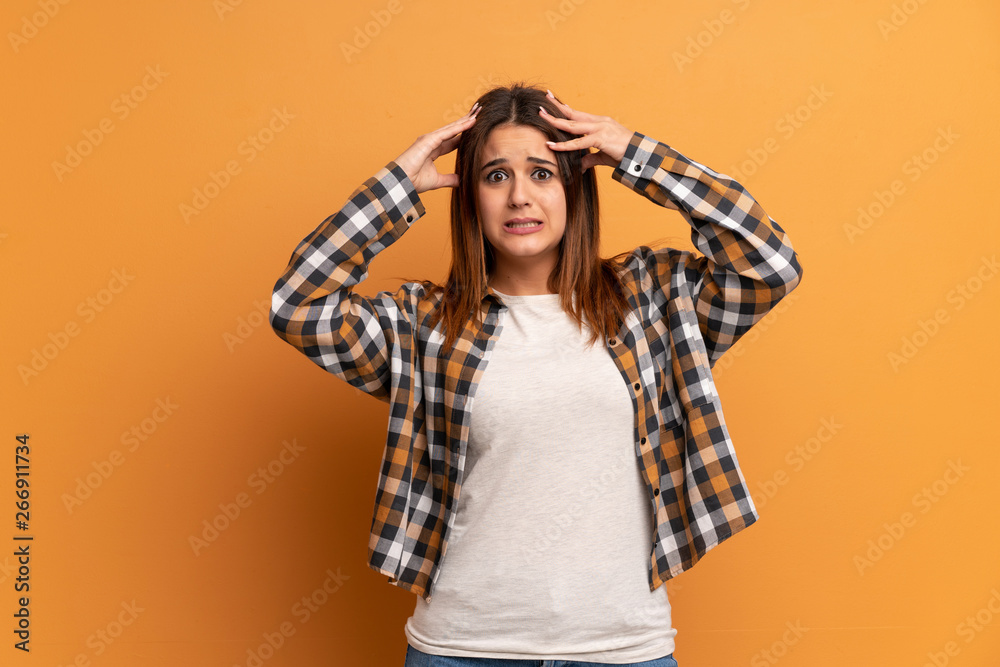 Young woman over brown wall with surprise expression Young woman over brown wall with surprise expression