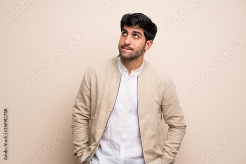 Young man over isolated wall with confuse face expression