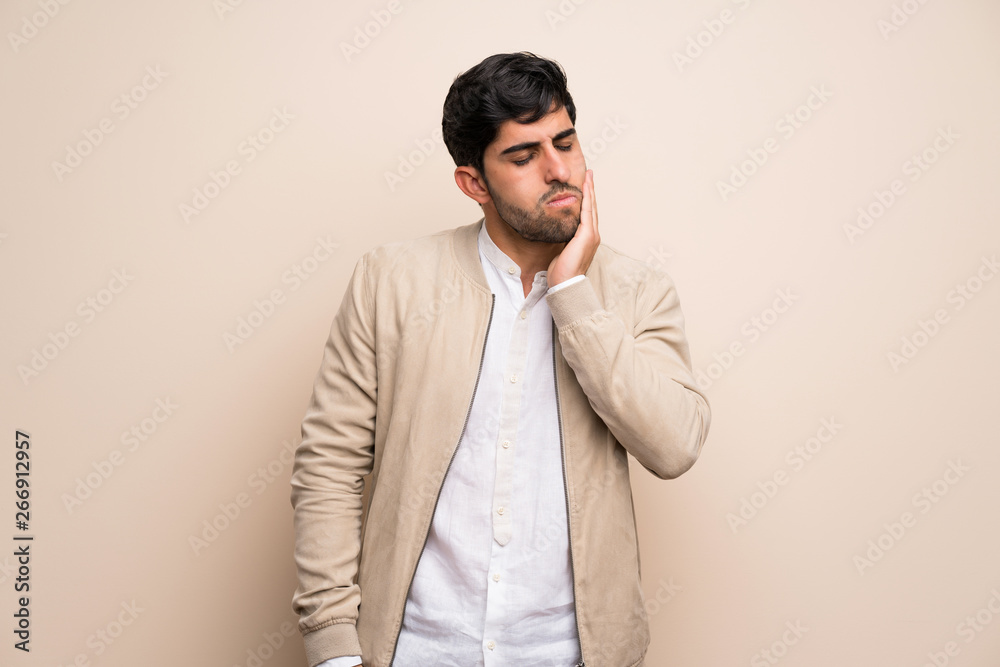 Young man over isolated wall with toothache Young man over isolated wall with toothache